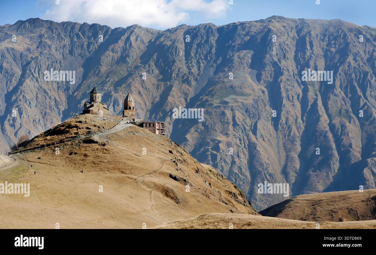 La vue de l'ancienne Gergeti Trinity Church ou Holy Trinity Church près du village de Stepantsminda en Géorgie, Caucase magnifique paysage large, montagne Banque D'Images
