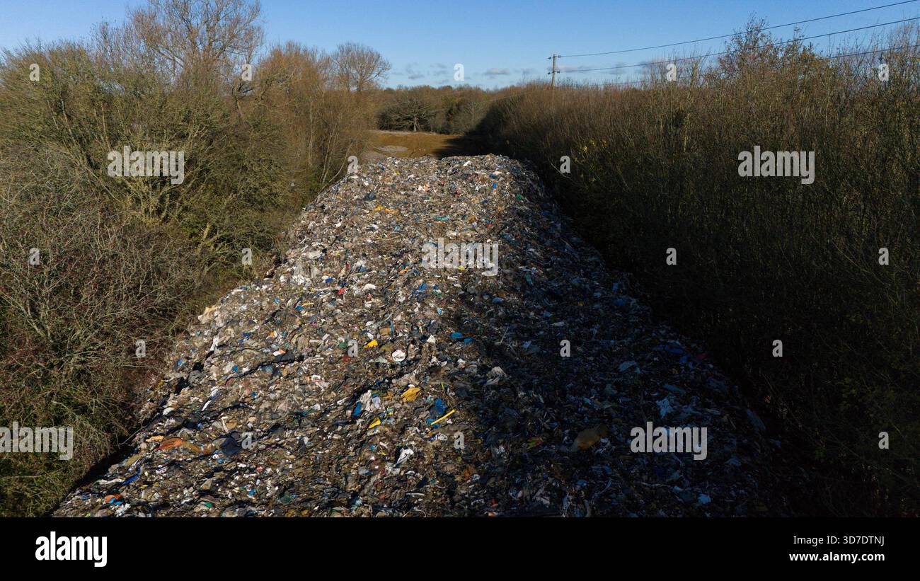 Une vue générale de la montagne de déchets de 150 m de long qui a été déversée illégalement à côté de l'A34 et près de la rivière Cherwell à Kidlington, Oxfordshire. Date de la photo : mardi 25 novembre 2025. Banque D'Images