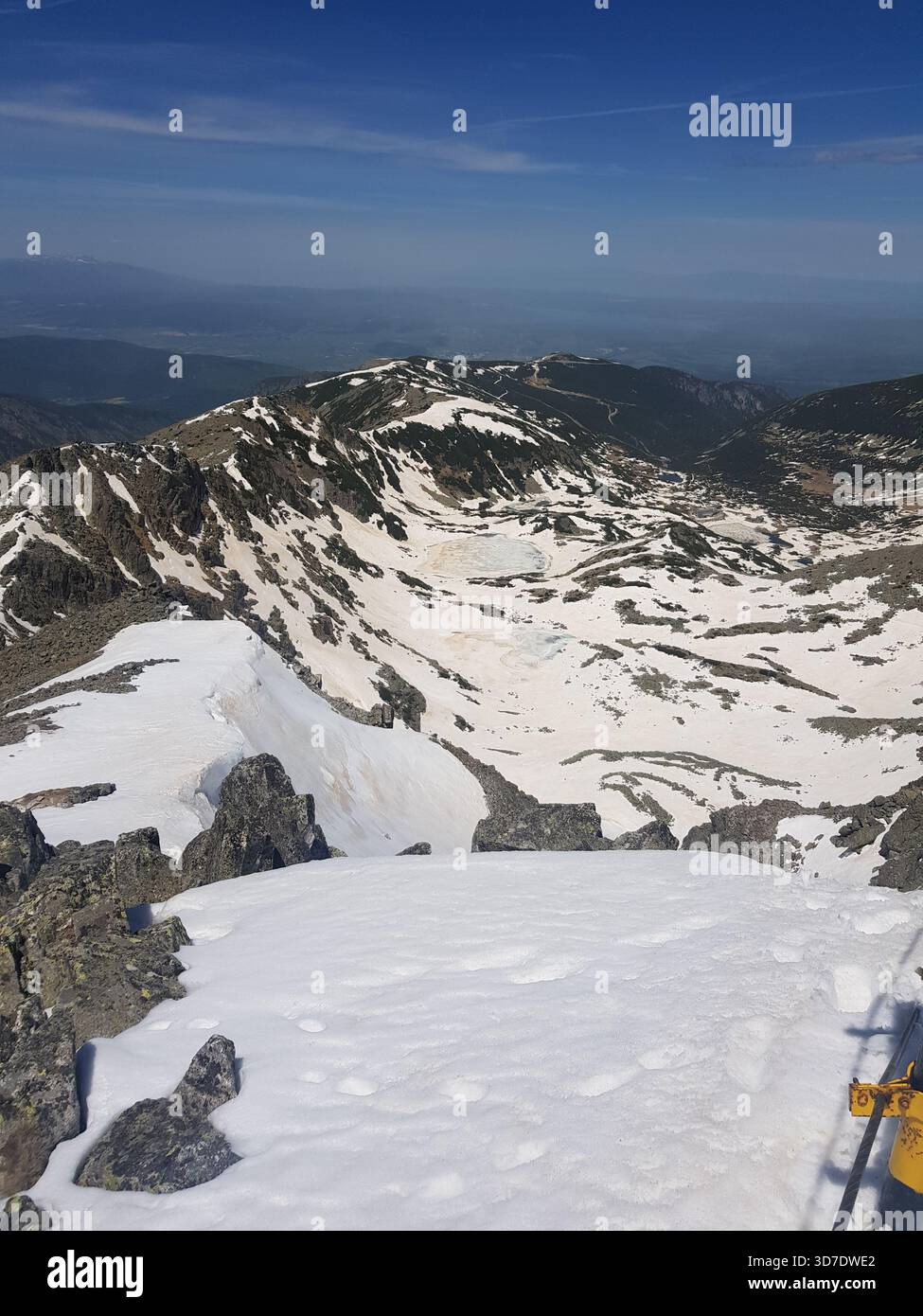 Crêtes enneigées et pics rocheux sur le mont Musala, la plus haute montagne des Balkans, avec des paysages hivernaux spectaculaires et un ciel bleu clair. Banque D'Images