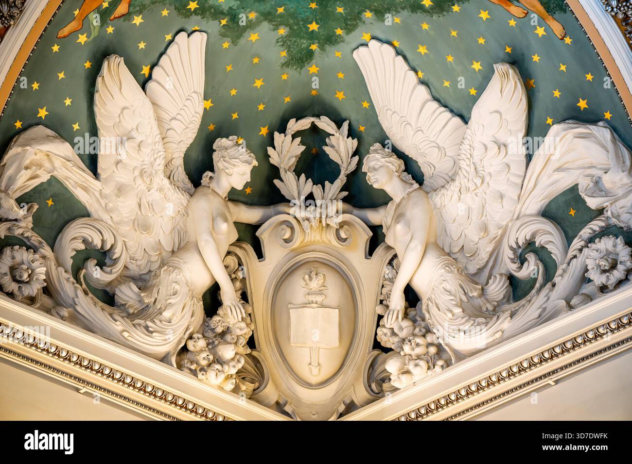 WASHINGTON DC — des figures allégoriques ailées, communément appelées anges, ornent le plafond orné de la Grande salle de la Bibliothèque du Congrès Thomas Jefferson Building. Ces sculptures blanches détaillées sont placées sur un fond étoilé vert foncé, soutenant un emblème central avec un livre ouvert et une torche. Ils font partie intégrante du schéma architectural et artistique élaboré du bâtiment des Beaux-Arts, achevé en 1897. Le Thomas Jefferson Building est le plus ancien bâtiment de la Bibliothèque du Congrès, réputé pour son symbolisme riche et ses arts décoratifs Banque D'Images