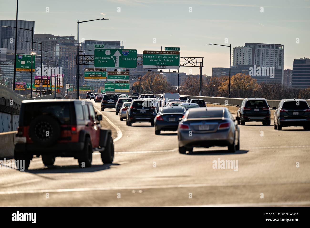 WASHINGTON DC — la circulation se déplace sur la I-395 South sur le pont de la 14e rue, regardant de East Potomac Park vers Crystal City à Arlington, Virginie. Les panneaux aériens dirigent les conducteurs vers Alexandria, Richmond et l'aéroport national Ronald Reagan de Washington. Ce complexe de ponts majeur relie Washington DC avec le nord de la Virginie à travers le fleuve Potomac. L'horizon d'Arlington, y compris le quartier de Crystal City, est visible en arrière-plan. Banque D'Images