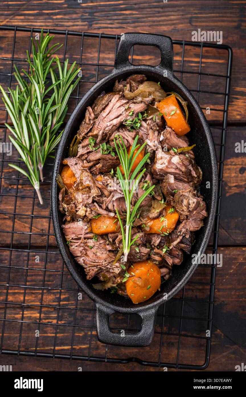 Poêle de boeuf bourguignon avec du boeuf tendre, des carottes et des champignons. fond en bois. vue de dessus. Banque D'Images