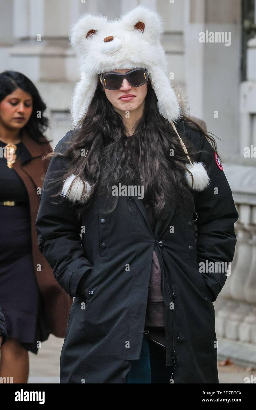 Londres, Royaume-Uni. 25 novembre 2025. Une jeune femme marche le long de Whitehall à Westminster dans un chapeau moelleux de style anime contre le froid par une journée brillante mais froide à Londres. Crédit : Imageplotter/Alamy Live News Banque D'Images