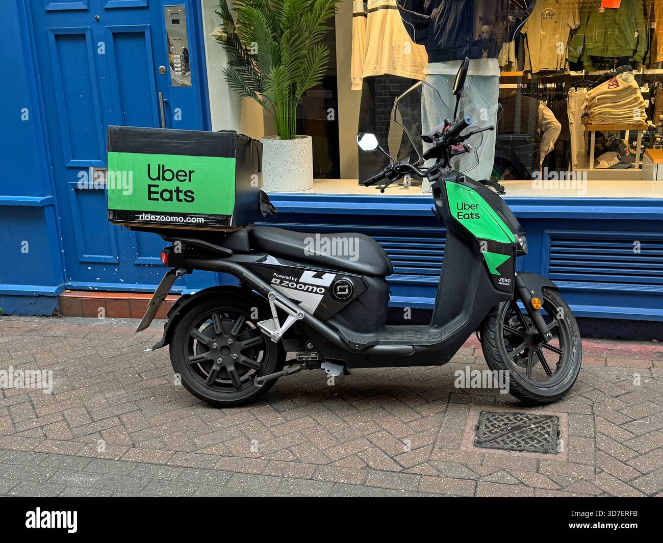 Londres, Royaume-Uni - 30 octobre 2024 : scooter de livraison Uber Eats garé devant un étalage de magasin. Banque D'Images