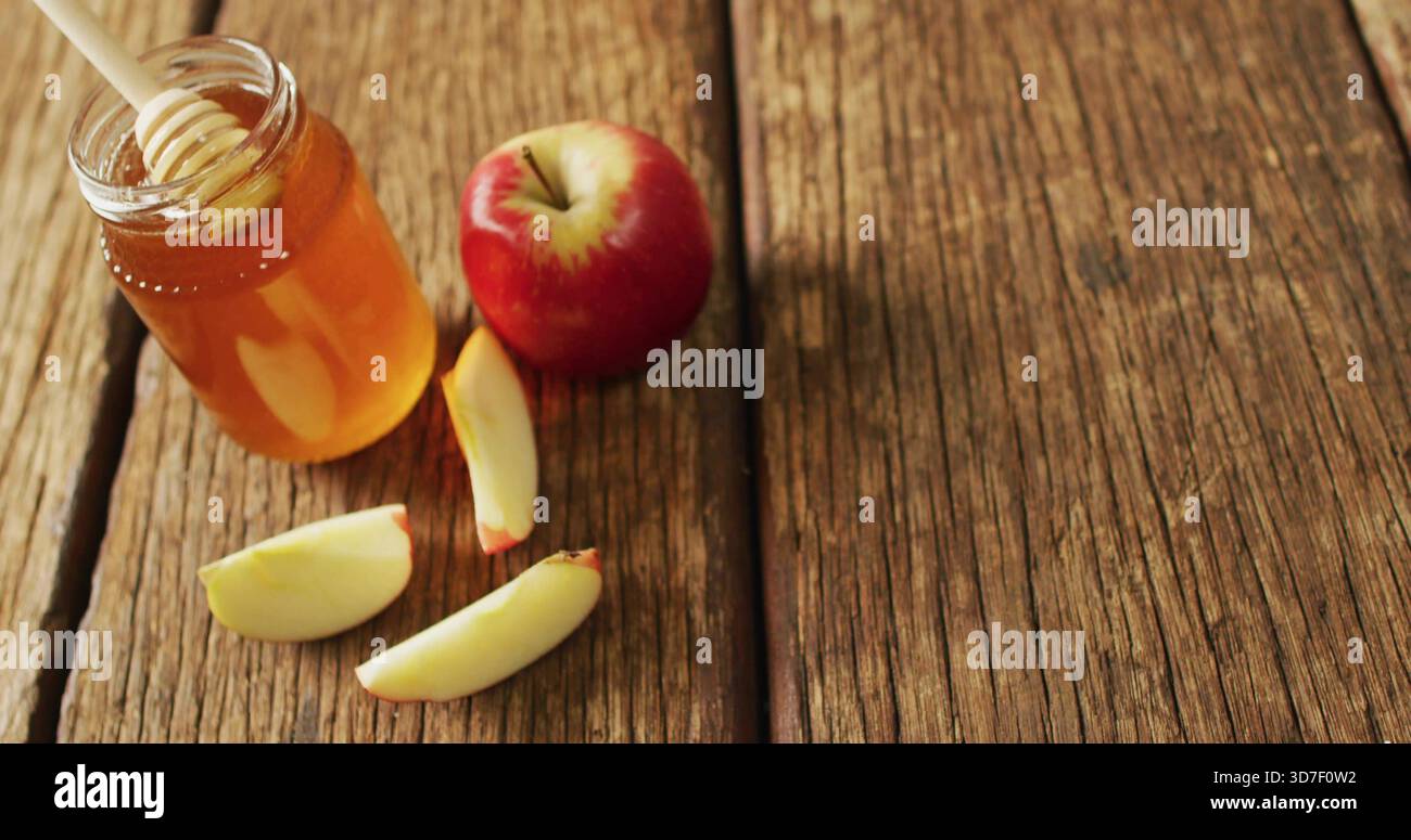 Affichage pot de miel avec plongeur en bois, pomme rouge et trois tranches sur la table rustique, espace de copie Banque D'Images