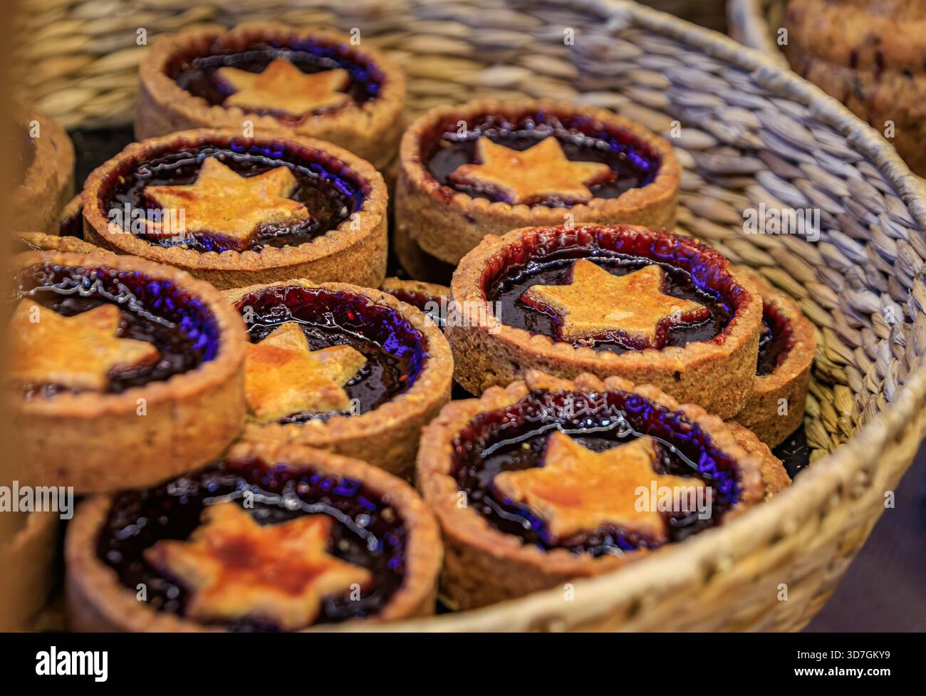 Un panier rempli de tartes Linzer traditionnelles avec des surcroûtes en forme d'étoile et une garniture de confiture de framboises au marché de Noël de Strasbourg, en France Banque D'Images