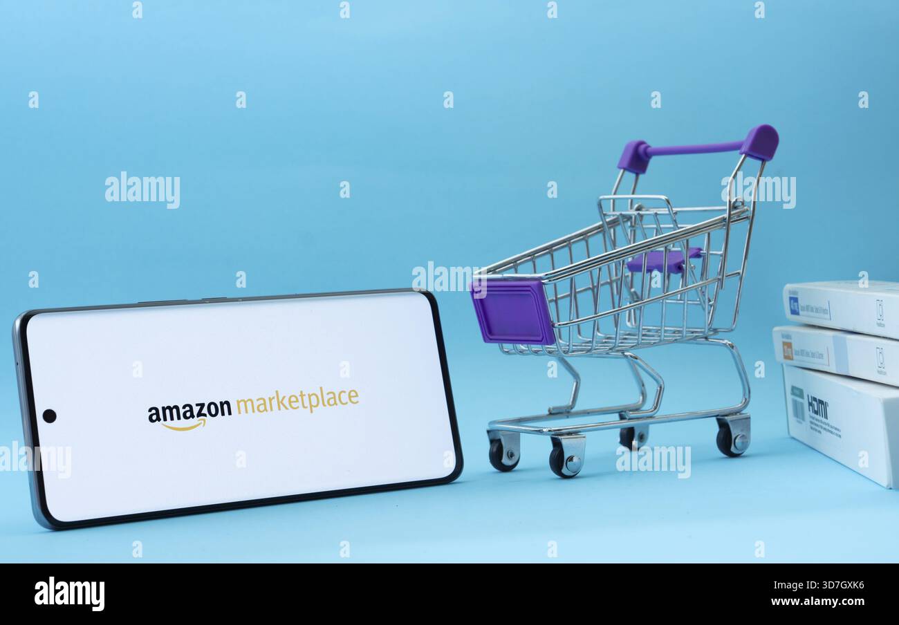 Dhaka, Bangladesh- 21 novembre 2025 : smartphone avec le logo amazon Marketplace à côté d'un petit panier et de boîtes sur un fond bleu Banque D'Images