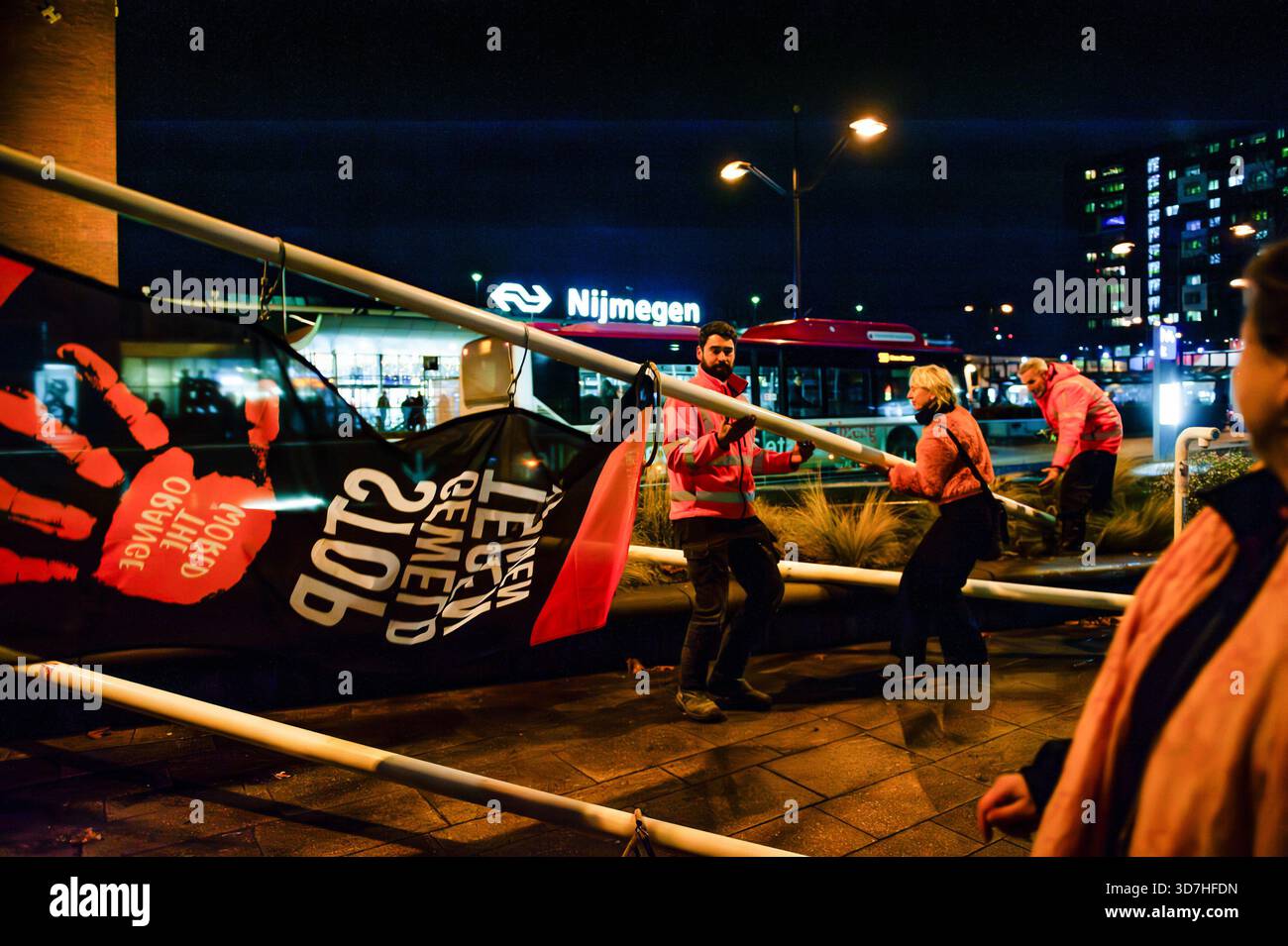 Une femme aide deux ouvriers à hisser le drapeau orange pendant le rassemblement. À l'occasion de la Journée internationale pour l'élimination de la violence à l'égard des femmes, les gens se sont rassemblés pour hisser les drapeaux de la campagne mondiale « Orange the World » óa visant à soutenir les femmes et les filles. Pendant « Orange the World », la campagne mondiale des Nations Unies pour les femmes, dans plus de 100 pays, des bâtiments et autres objets sont illuminés en orange. De plus, des débats, des expositions, des démonstrations et diverses autres activités sont organisées. (Photo de Ana Fernandez/SOPA images/SIPA USA) Banque D'Images