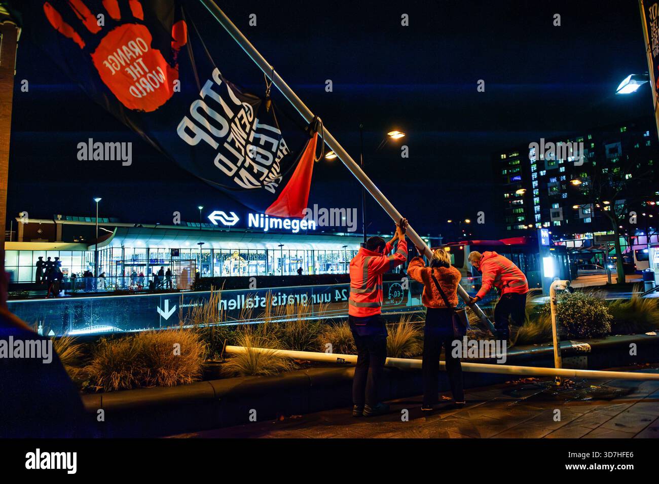 Les drapeaux « Orange the World » sont visibles devant la gare pendant le rallye. À l'occasion de la Journée internationale pour l'élimination de la violence à l'égard des femmes, les gens se sont rassemblés pour hisser les drapeaux de la campagne mondiale « Orange the World » óa visant à soutenir les femmes et les filles. Pendant « Orange the World », la campagne mondiale des Nations Unies pour les femmes, dans plus de 100 pays, des bâtiments et autres objets sont illuminés en orange. De plus, des débats, des expositions, des démonstrations et diverses autres activités sont organisées. (Photo de Ana Fernandez/SOPA images/SIPA USA) Banque D'Images
