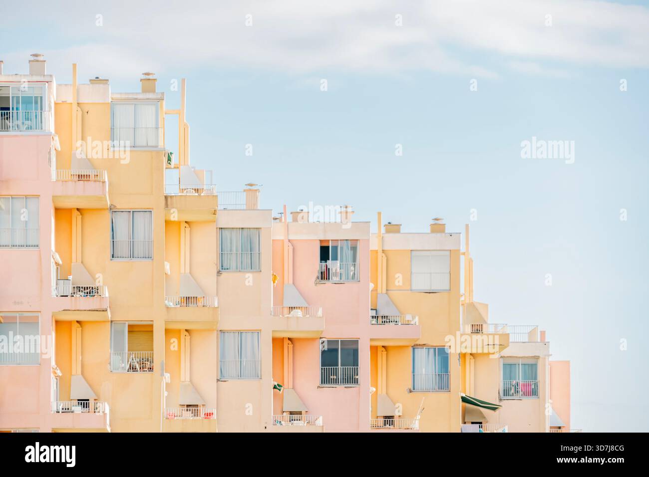 Motif géométrique en gradins d'un immeuble résidentiel avec balcons, peint dans des couleurs pastel douces Banque D'Images
