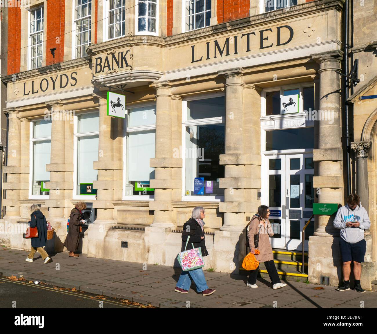 Succursale de Lloyds Bank Limited, Devizes, Wiltshire, Angleterre, Royaume-Uni personnes passant sur le trottoir de rue Banque D'Images
