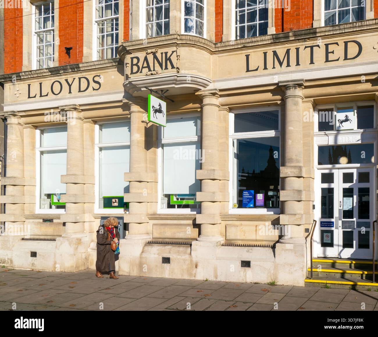 Succursale de Lloyds Bank Limited, Devizes, Wiltshire, Angleterre, Royaume-Uni personnes passant sur le trottoir de rue Banque D'Images
