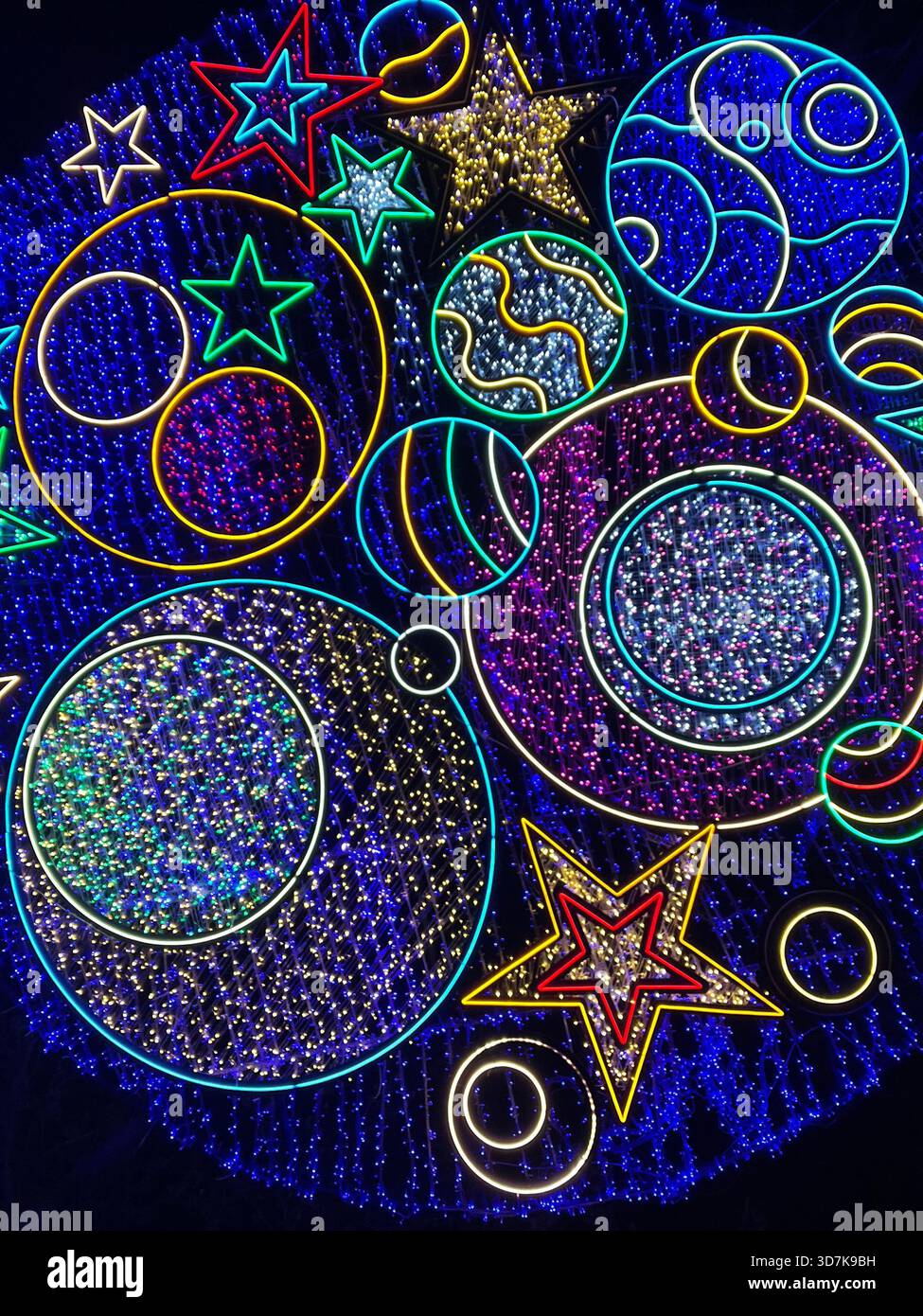 Installation lumineuse colorée sur le thème cosmique avec des étoiles et des planètes brillantes, créant un spectacle nocturne vibrant dans le parc Mellat de Téhéran. Banque D'Images