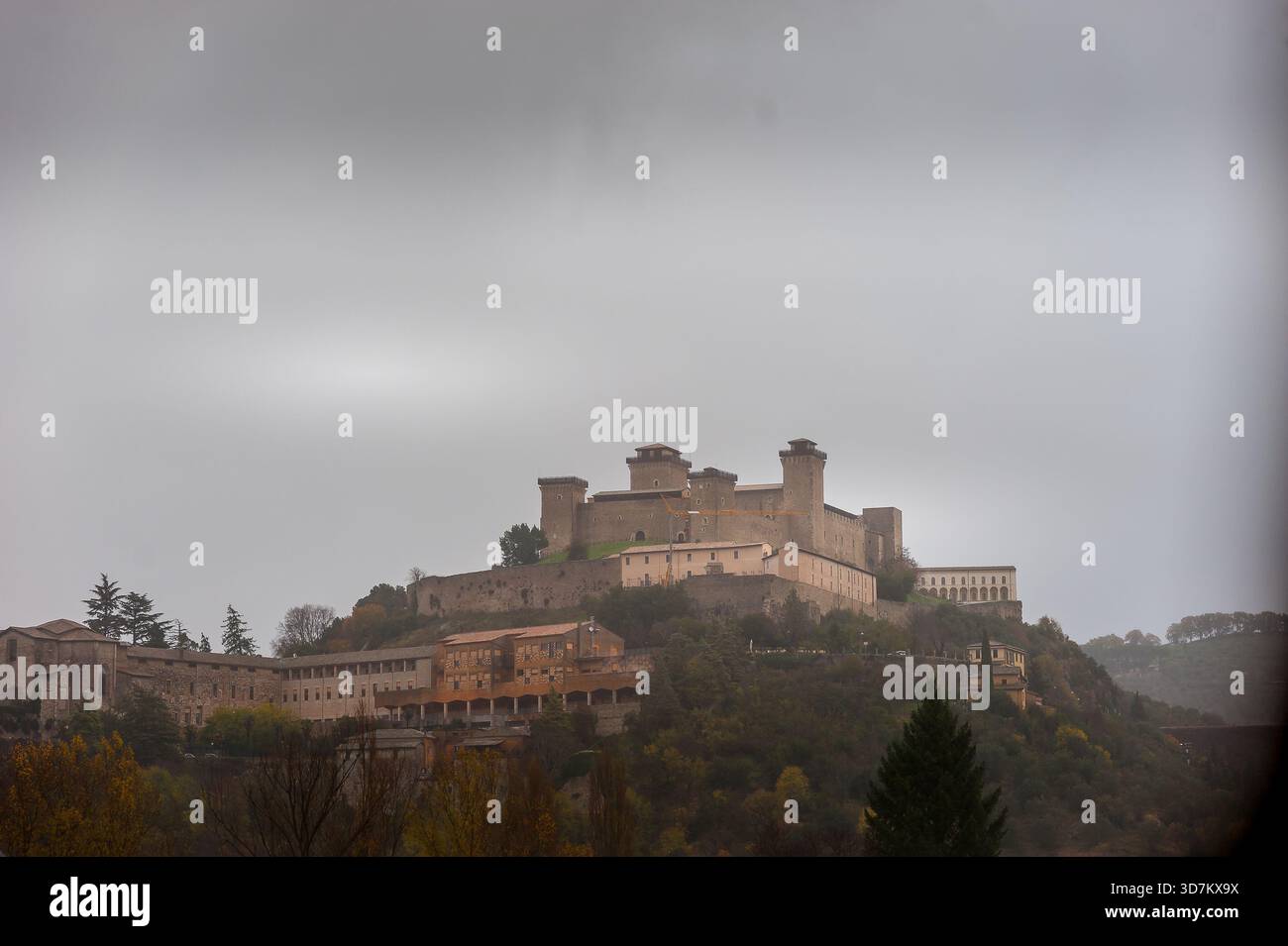 Forteresse médiévale perchée surplombant une ville italienne un jour nuageux Banque D'Images