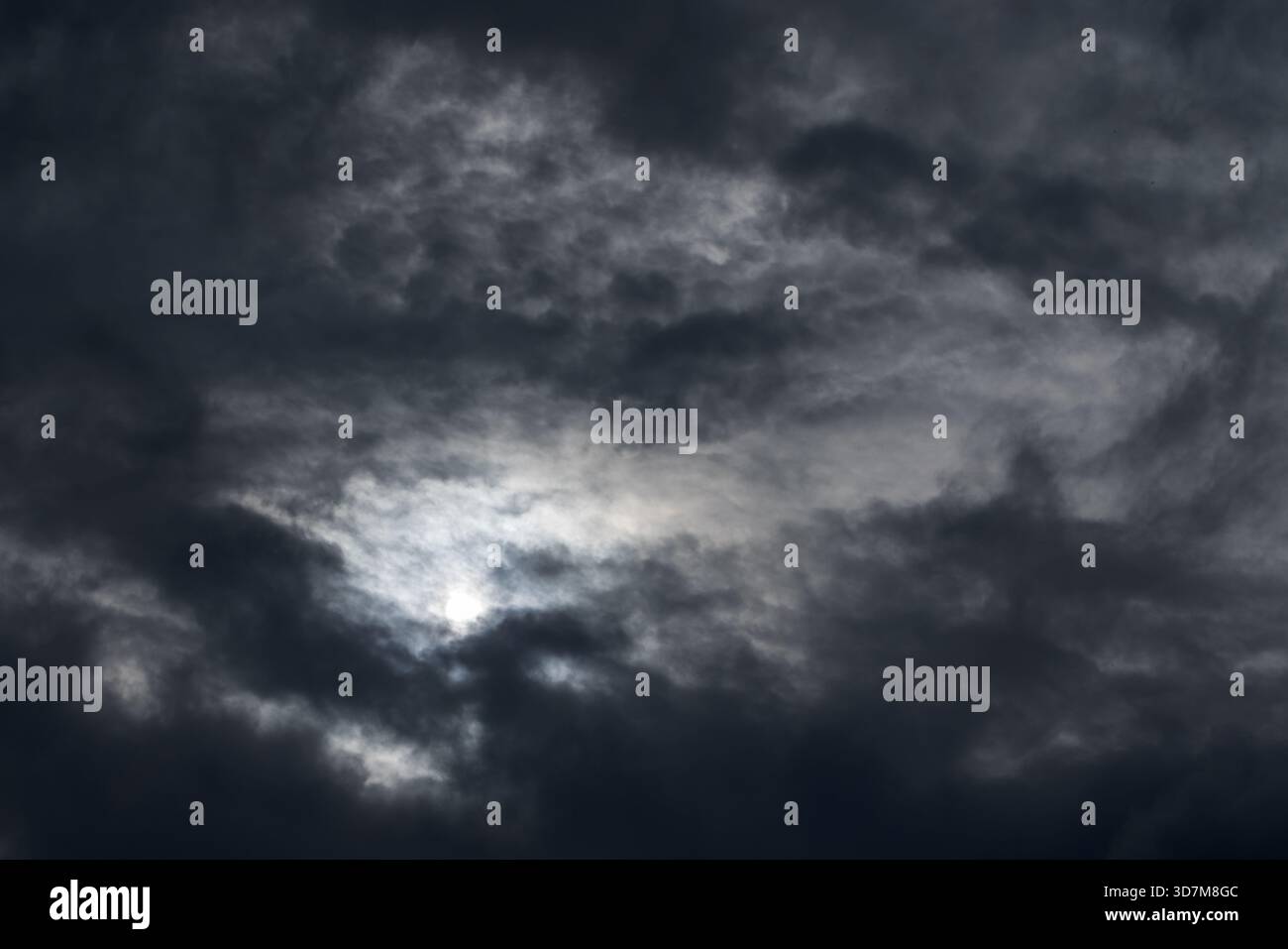Un ciel couvert sombre spectaculaire avant la tempête avec des nuages épais et un soleil faible se perçant, créant une atmosphère sombre et une lumière douce. BA naturel Banque D'Images