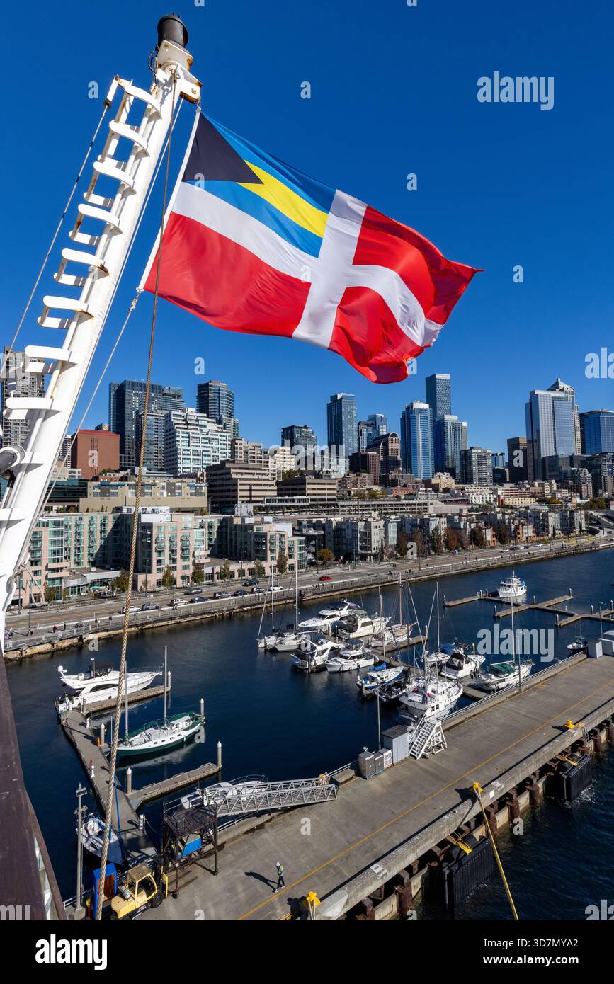 Vue sur l'horizon du centre-ville de Seattle depuis le quai 66 avec drapeau rouge civil des Bahamas au premier plan - Seattle, Washington, États-Unis Banque D'Images