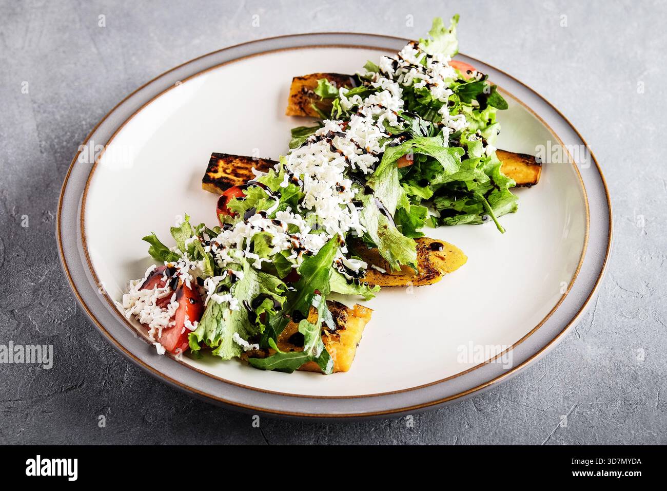 tranches de polenta carbonisées recouvertes de roquette et de parmesan rasé fini de zeste de citron et d'huile d'herbe placage rustique chaud parfait Banque D'Images