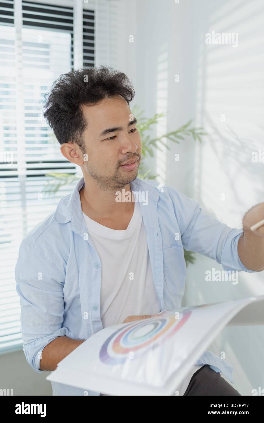 Un concepteur créatif travaille sur la planification de l'interface utilisateur UX, la révision des wireframes et l'ajustement des schémas de couleurs pour un projet d'application mobile, montrant Focus an Banque D'Images