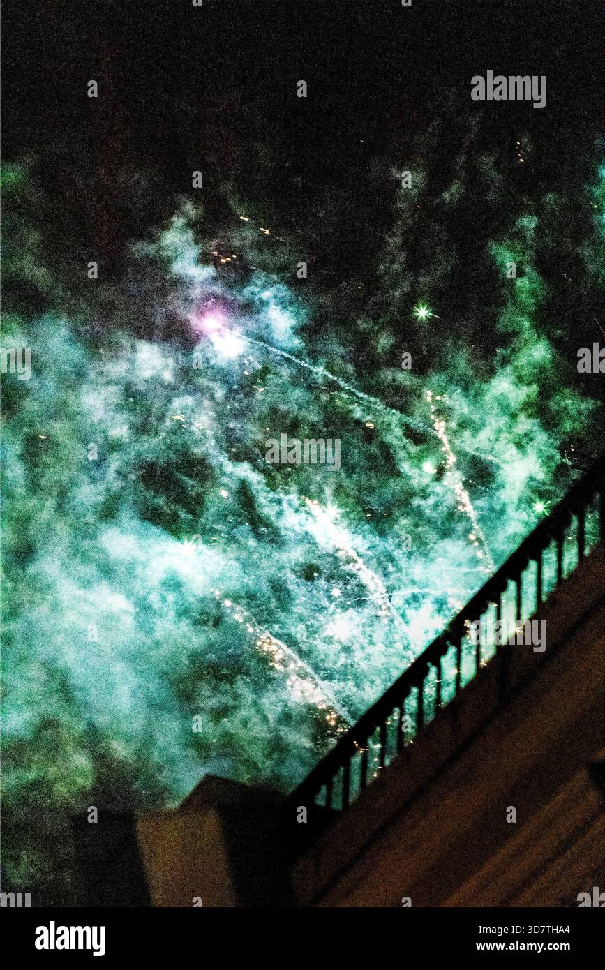 Feux d'artifice verts tirés d'un toit Banque D'Images