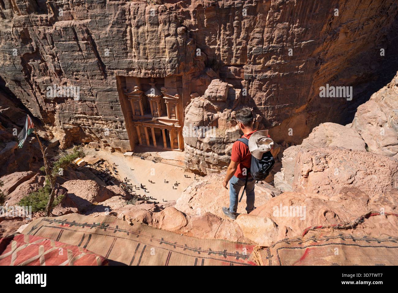 Touriste debout sur le bord de falaise surplombant le Trésor à Petra, Jordanie Banque D'Images