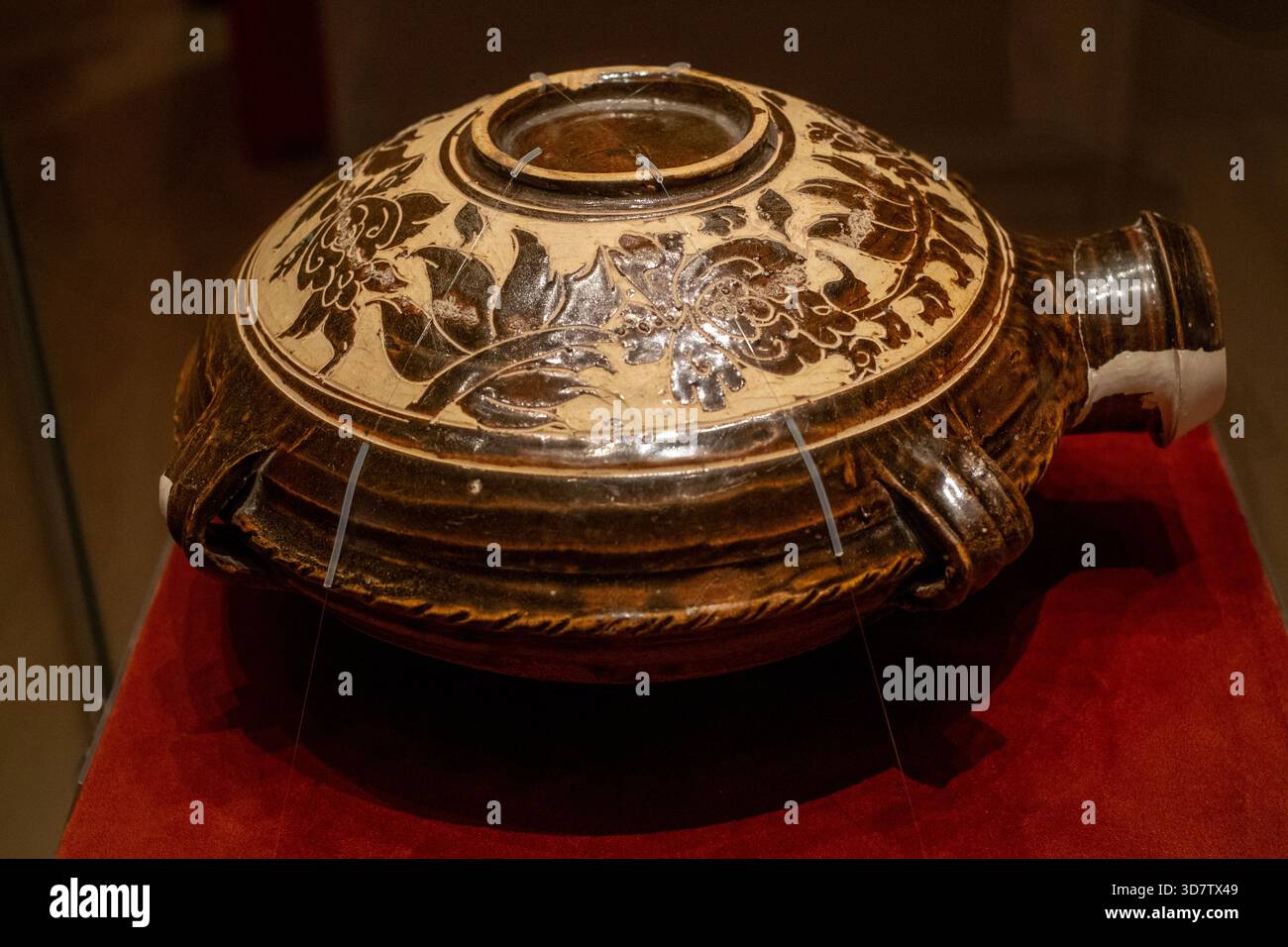 Flacon plat à quatre ergots vitré marron avec motif floral gravé de la dynastie Xixia. Collection du musée du comté de Haiyuan Banque D'Images