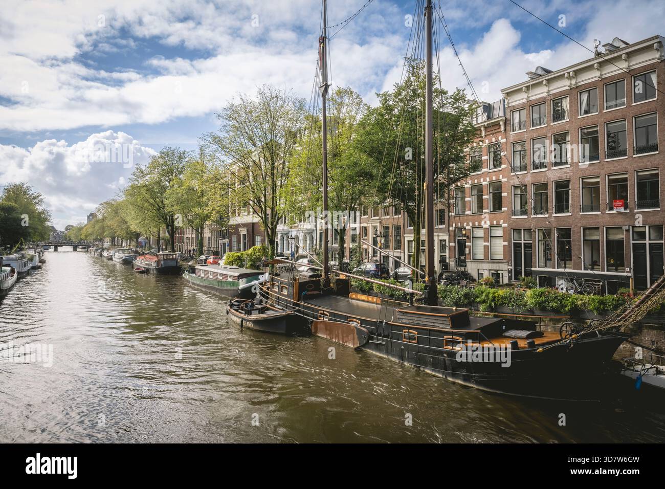Canal historique à Amsterdam avec bateau amarré et bâtiments classiques bordant la voie navigable. Amsterdam,. Pays-Bas Banque D'Images
