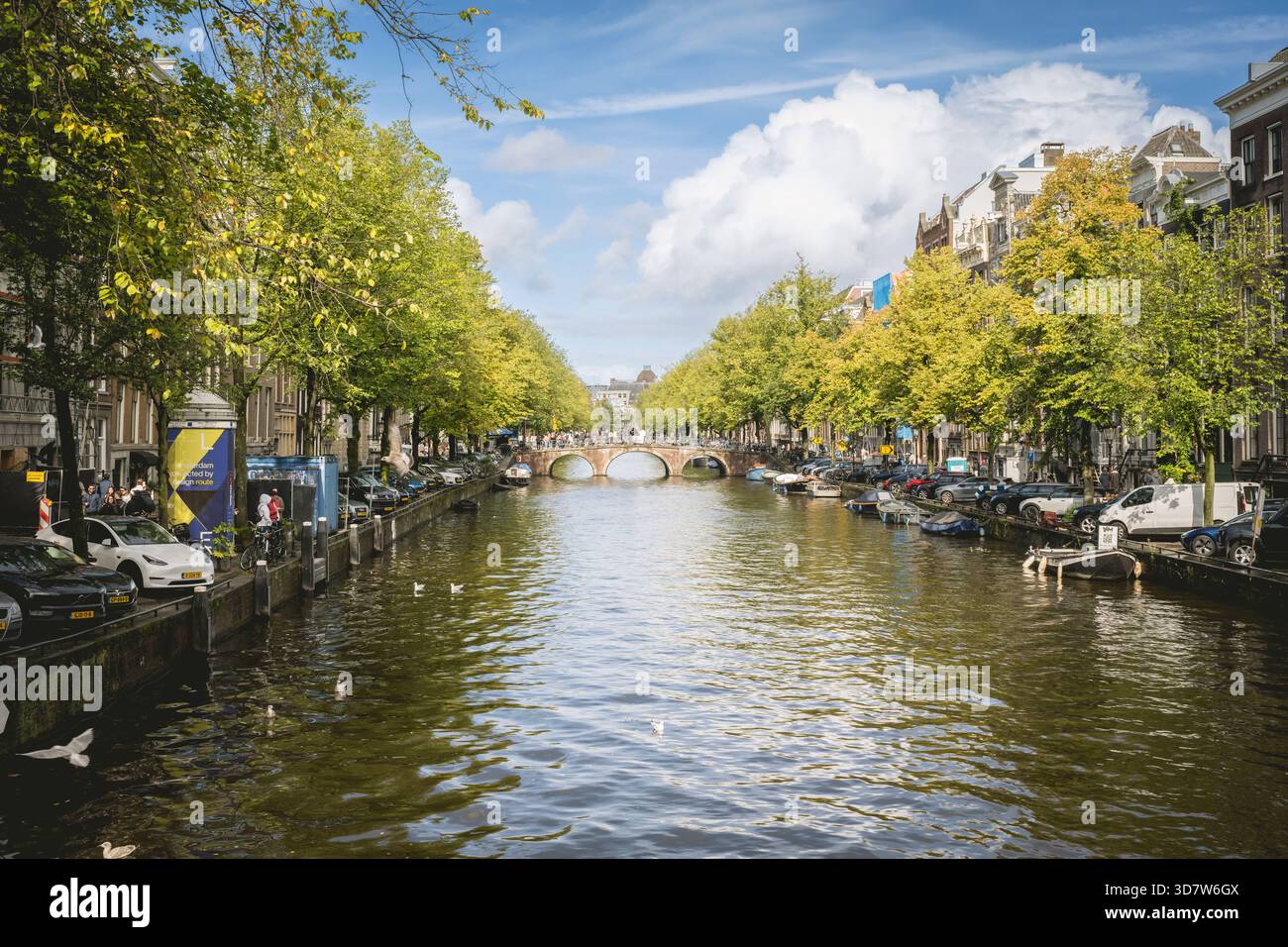 Vue panoramique sur un canal d'Amsterdam bordé d'arbres et de bâtiments historiques sous un ciel bleu. Amsterdam,. Pays-Bas Banque D'Images