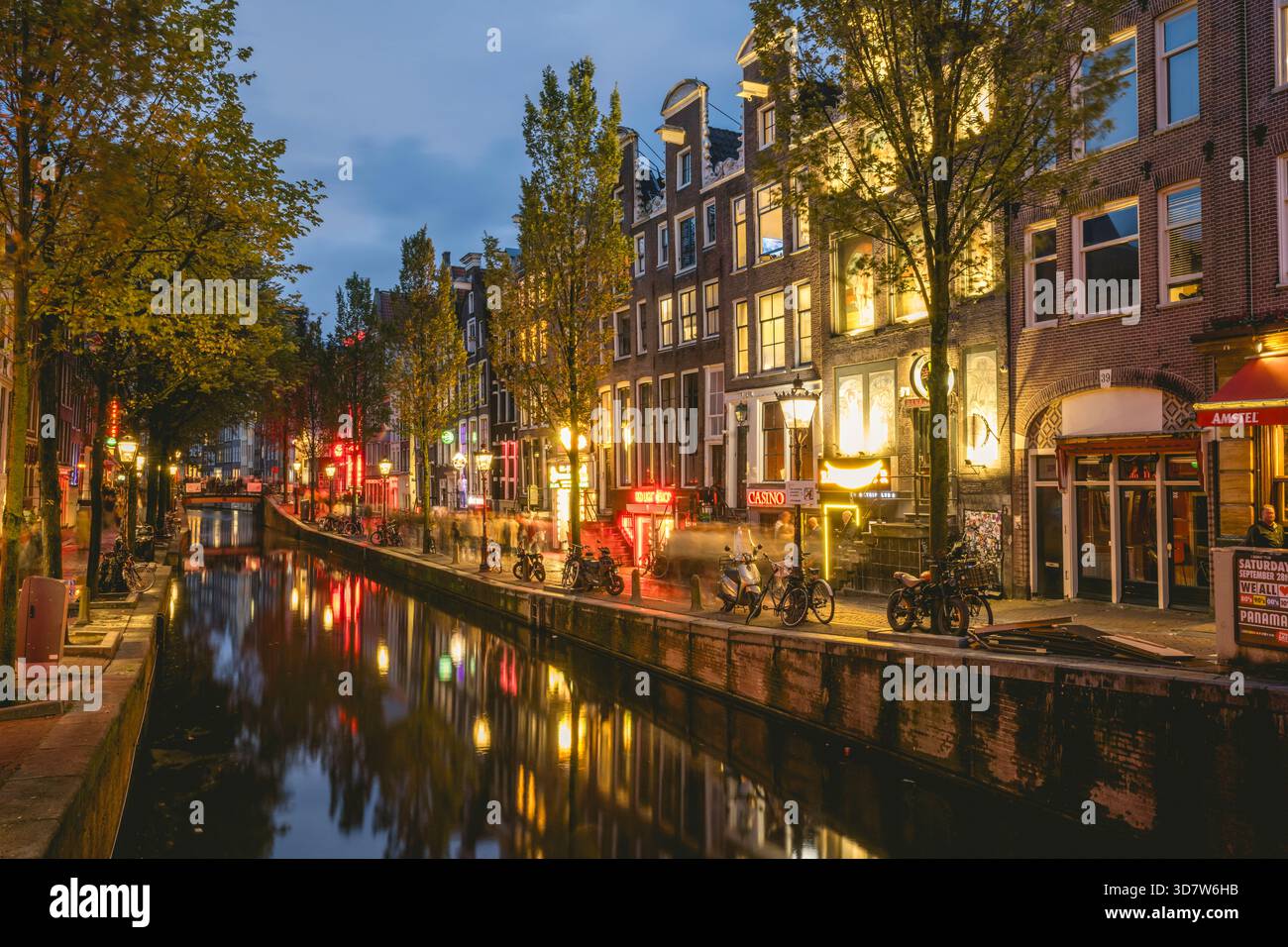 Canal d'Amsterdam au crépuscule avec des bâtiments illuminés et des reflets de rue dans l'eau. Amsterdam,. Pays-Bas Banque D'Images