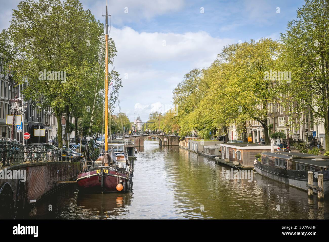 Des bateaux bordent un canal dans une charmante ville européenne avec des arbres luxuriants et des bâtiments historiques. Amsterdam,. Pays-Bas Banque D'Images