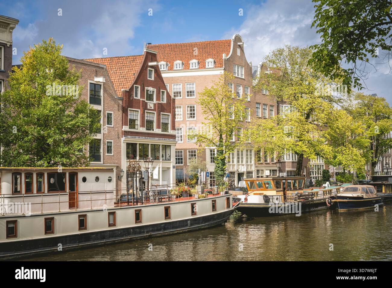 Maisons de canal historiques et bateaux sous un ciel partiellement nuageux à Amsterdam. Amsterdam,. Pays-Bas Banque D'Images