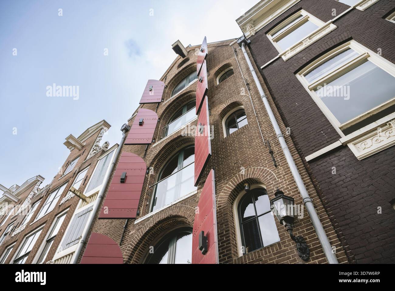 Grands bâtiments en briques avec volets roses décoratifs sur un ciel bleu. Amsterdam,. Pays-Bas Banque D'Images