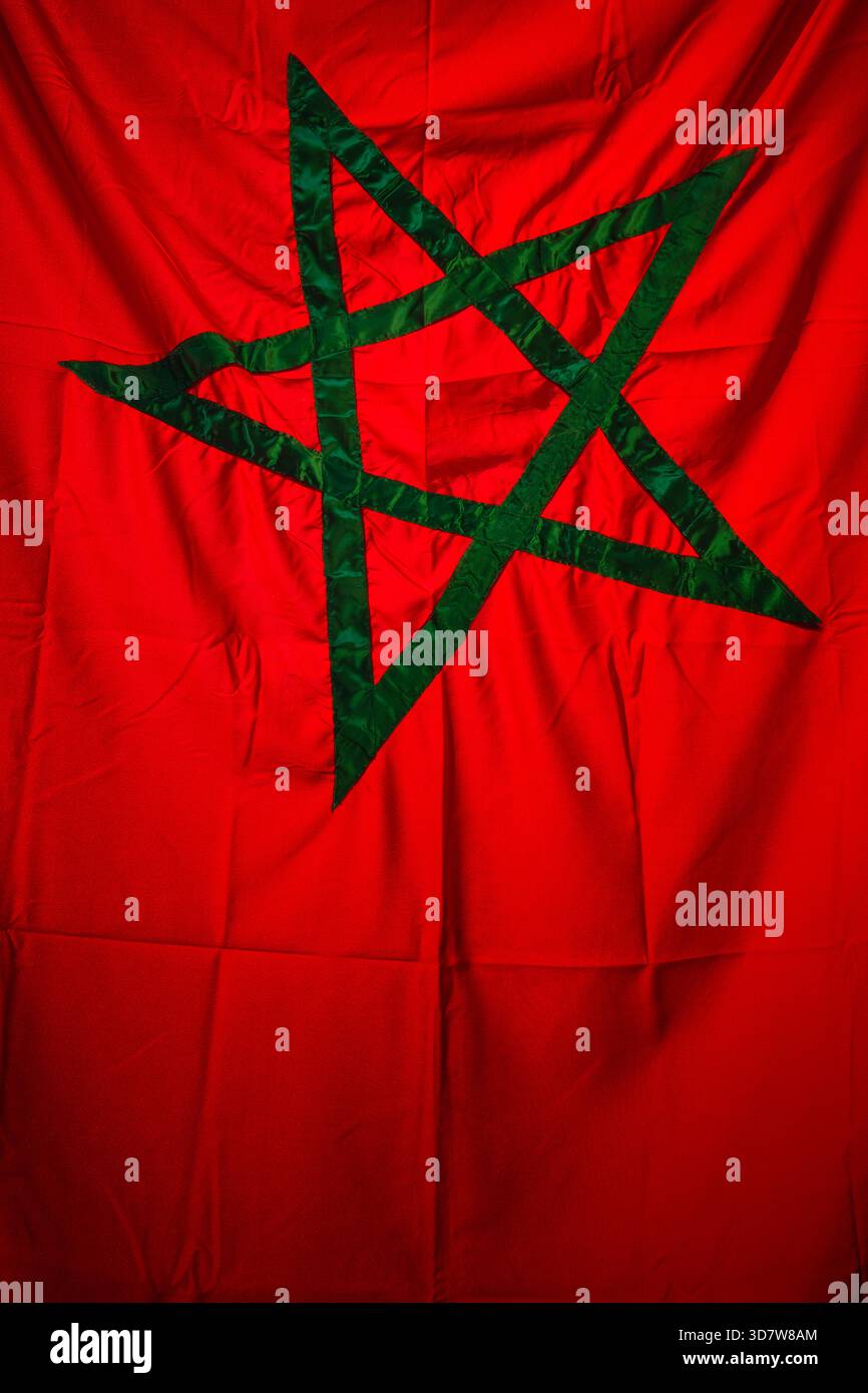 Drapeau rouge avec un emblème d'étoile verte à cinq branches au centre. Marrakech, Maroc Banque D'Images