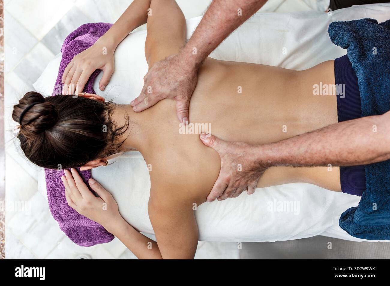 Femme recevant un massage relaxant du dos sur une table de massage blanche. Espagne Banque D'Images