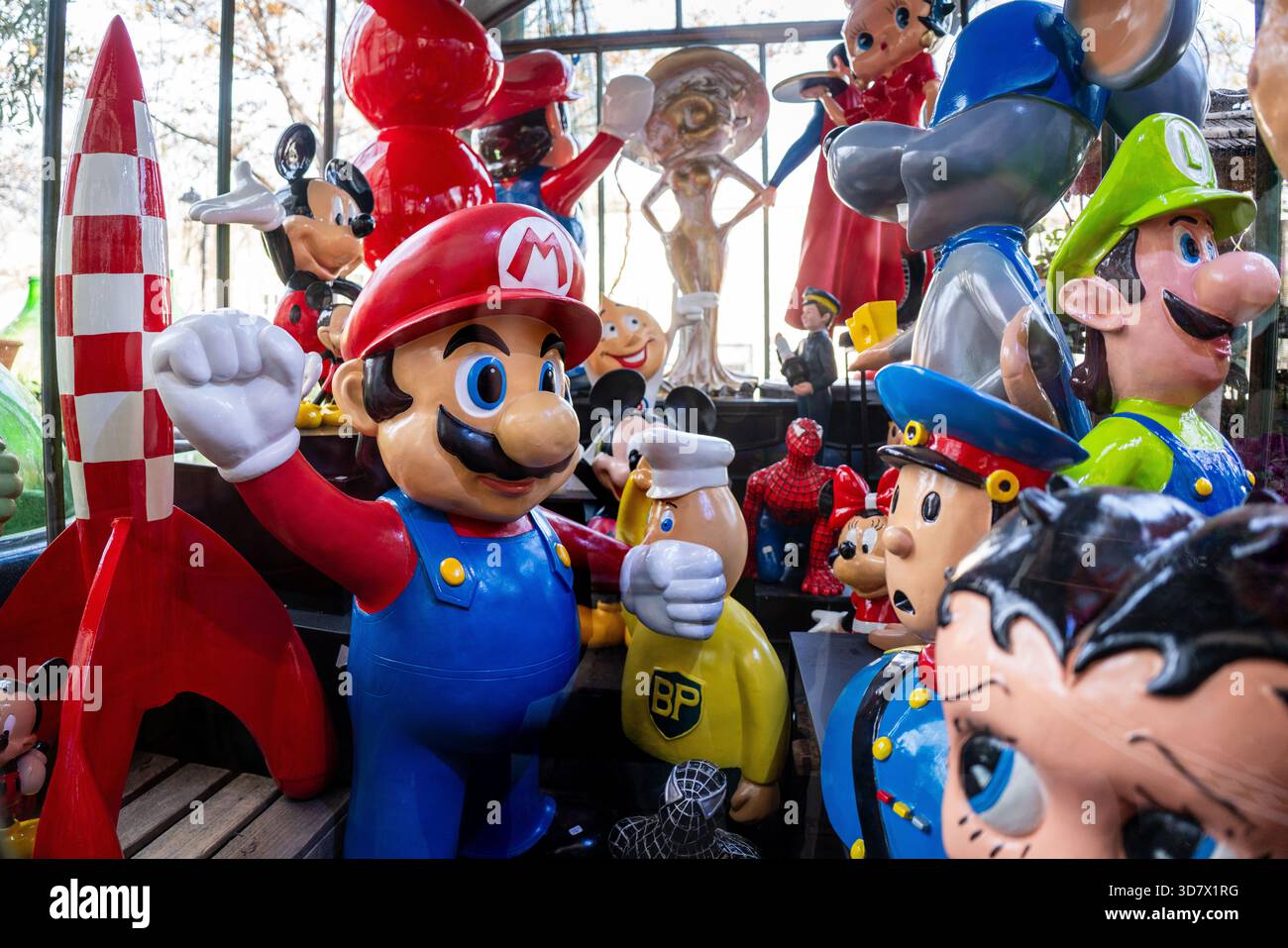 Collection variée de figurines de la culture pop exposées dans un magasin d'antiquités, mettant en vedette des personnages emblématiques de Nintendo, Disney et d'autres divertissements Banque D'Images