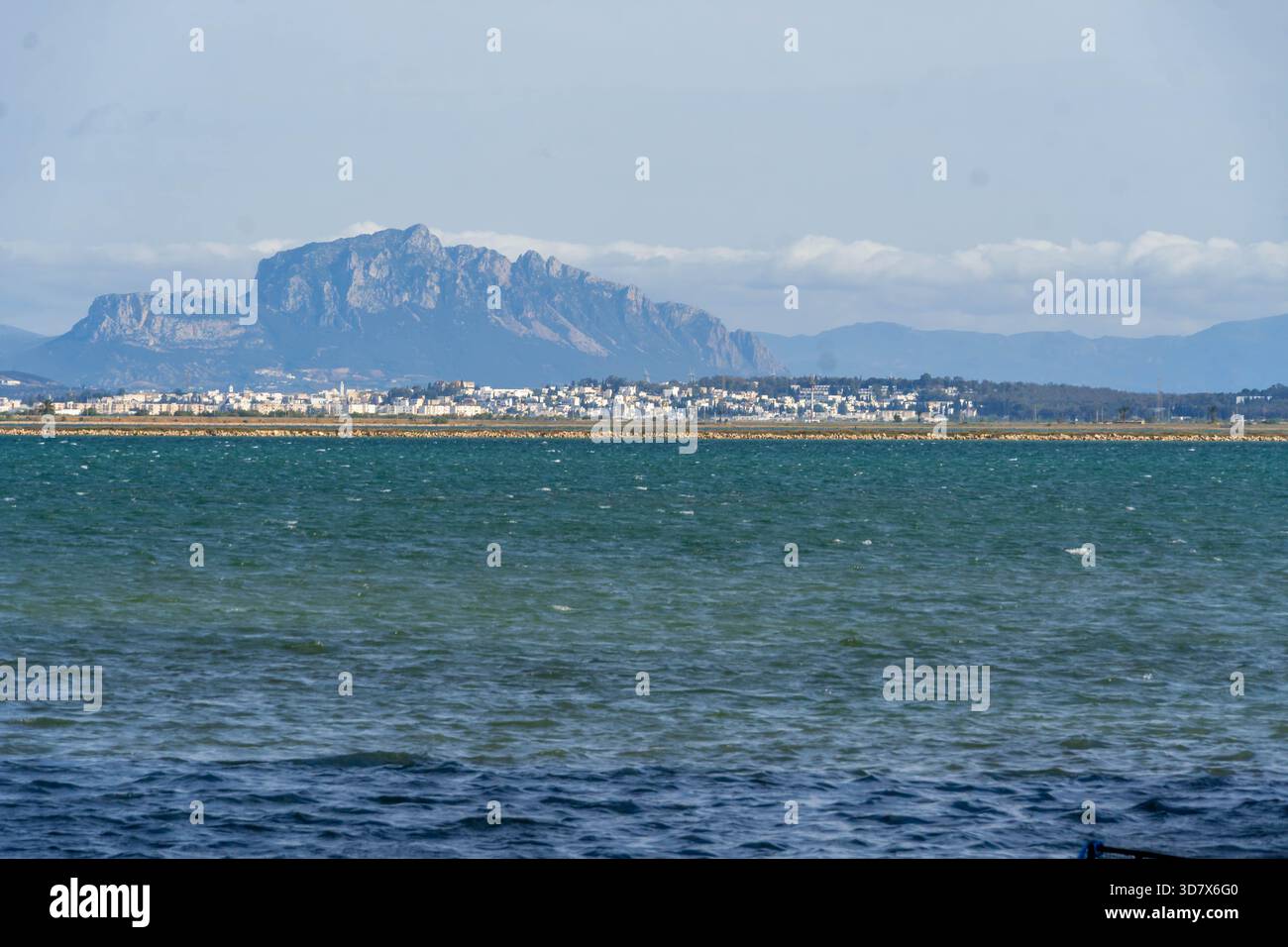 Banlieue côtière près de Tunis avec des bâtiments blancs le long du golfe de Tunis et les spectaculaires montagnes du Cap bon s'élevant derrière l'eau. Banque D'Images