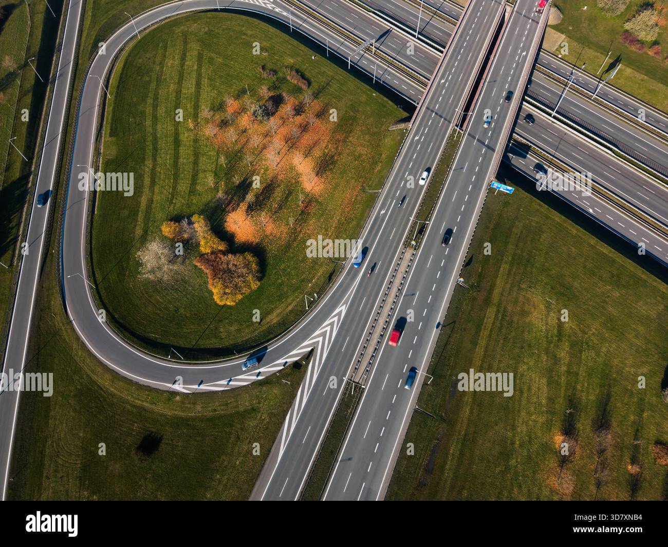 Arbres d'automne du pont de courbe de route aérienne. Vue de haut en bas d'un drone d'une jonction d'autoroute avec une courbe de route serrée, pont supérieur, et foli d'automne coloré Banque D'Images