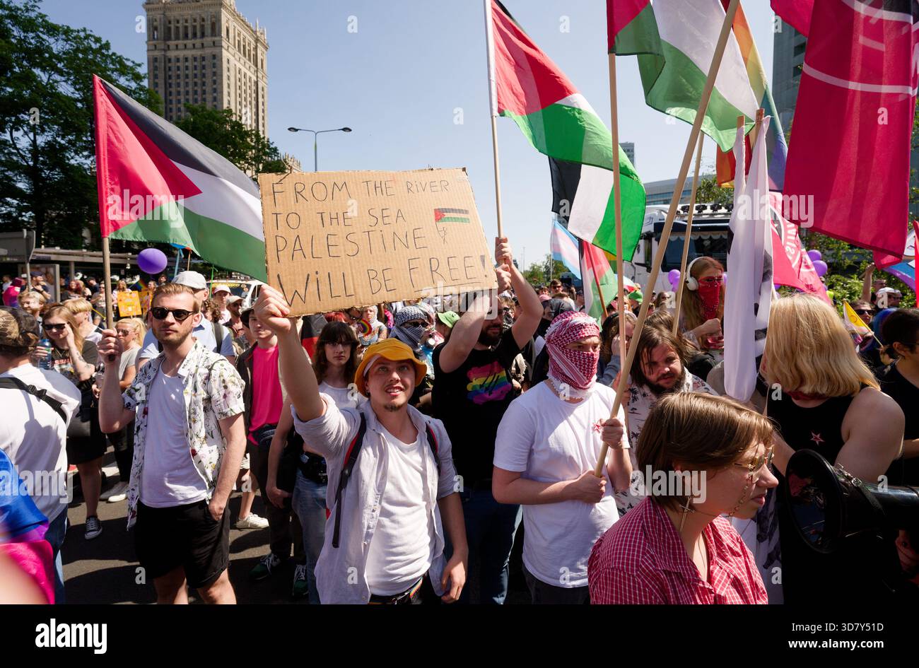 Les participants à la fierté de Varsovie (Parada Równości) tiennent des drapeaux palestiniens et une pancarte indiquant "DU FLEUVE À LA MER, LA PALESTINE SERA LIBRE". Banque D'Images