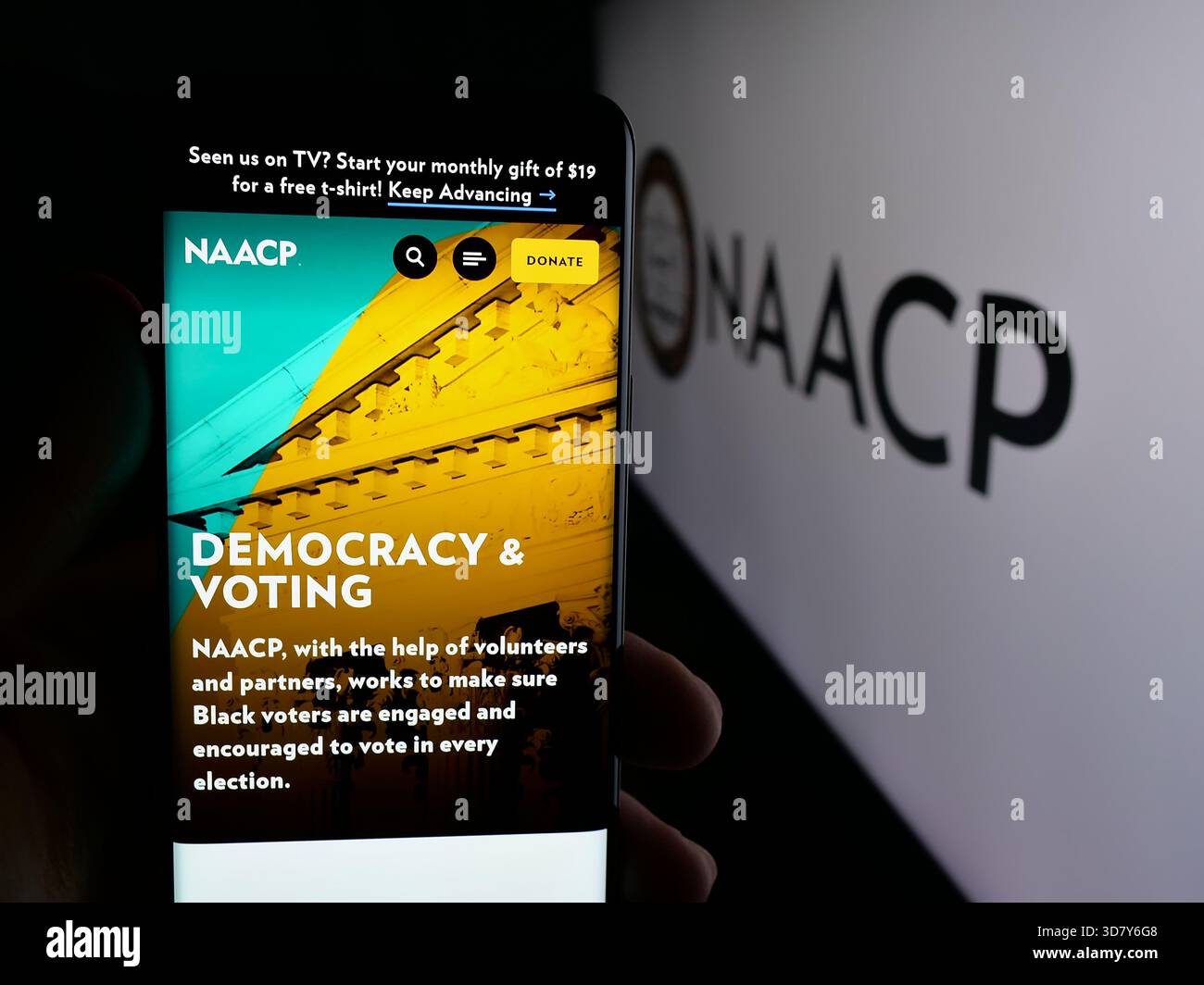 Stuttgart, Allemagne - 11-19-2025 : personne tenant un téléphone portable avec la page Web de l'association américaine des personnes de couleur NAACP sur l'écran devant le logo. Banque D'Images