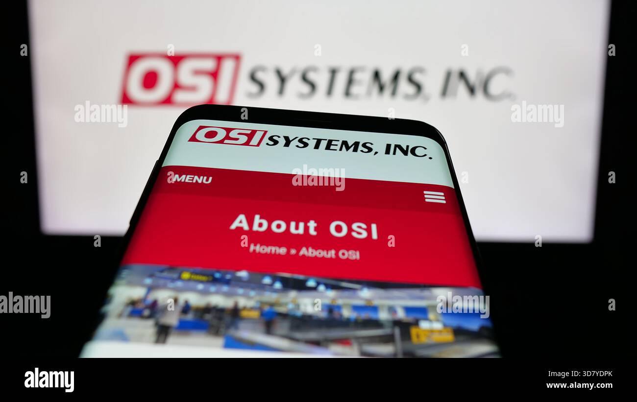 Stuttgart, Allemagne - 11-18-2025 : téléphone portable avec le site Web de la société de sécurité américaine OSI Systems Inc sur l'écran devant le logo. Banque D'Images