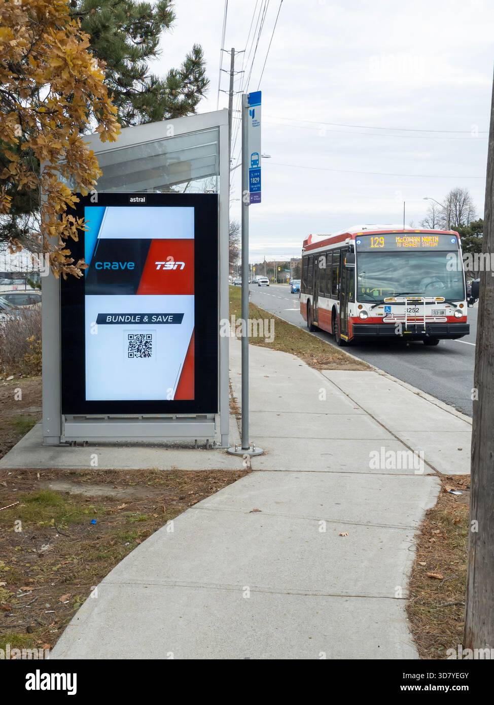 Trottoir urbain avec affichage publicitaire numérique et autobus de transport en commun approchant le jour couvert à Markham - Image de stock capturée avec un smartphone