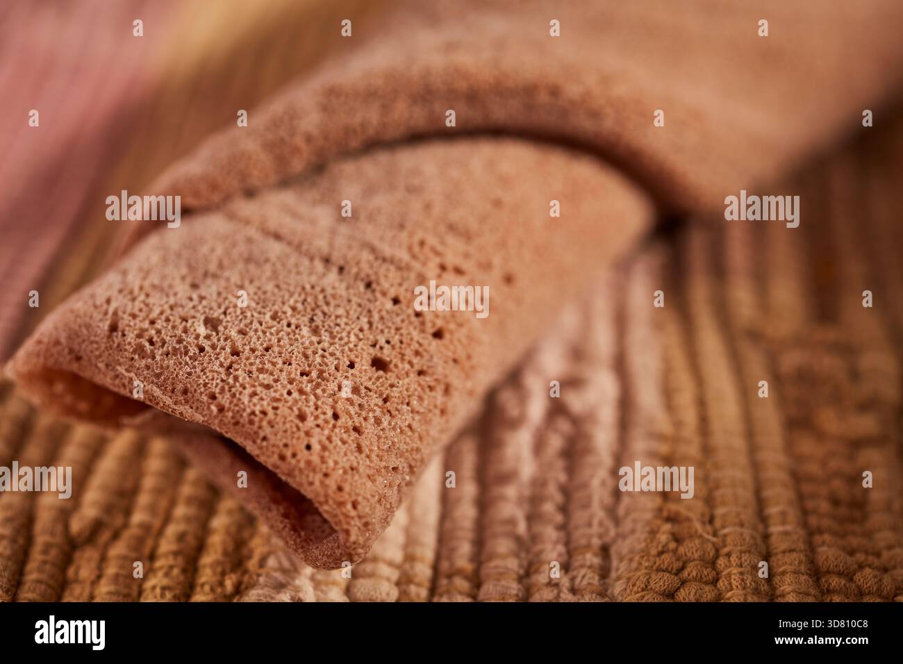 Un morceau roulé d'injera, le pain plat éthiopien fait de teff, une farine de spécialité locale Banque D'Images