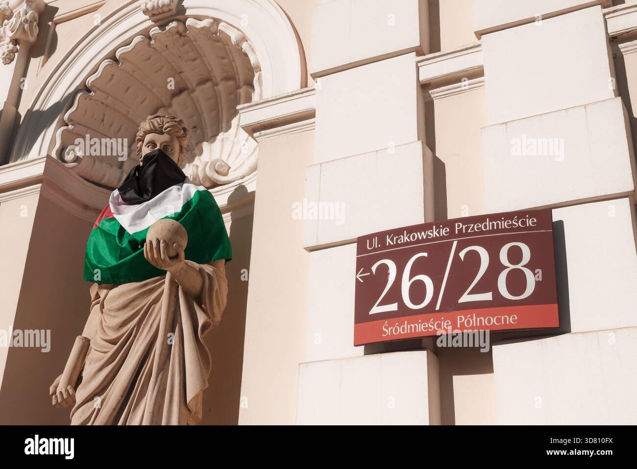 Statue à la porte historique de l'Université de Varsovie avec un visage couvert de drapeau palestinien après une manifestation étudiante pro-palestinienne. Banque D'Images