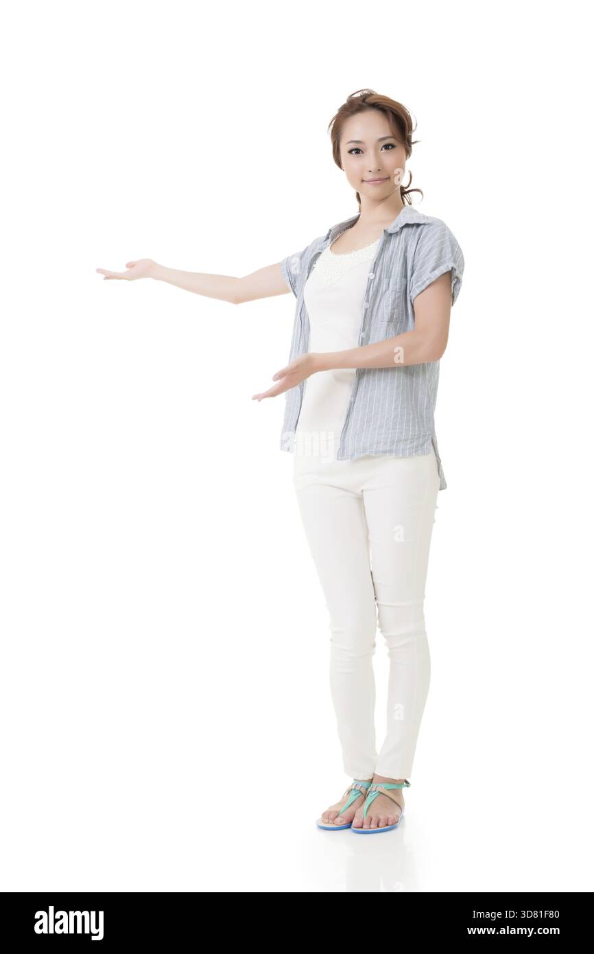Jeune asiatique Pretty Woman montrer, présenter, présenter quelque chose sur l'espace blanc. Pleine longueur. Isolé sur fond blanc Banque D'Images