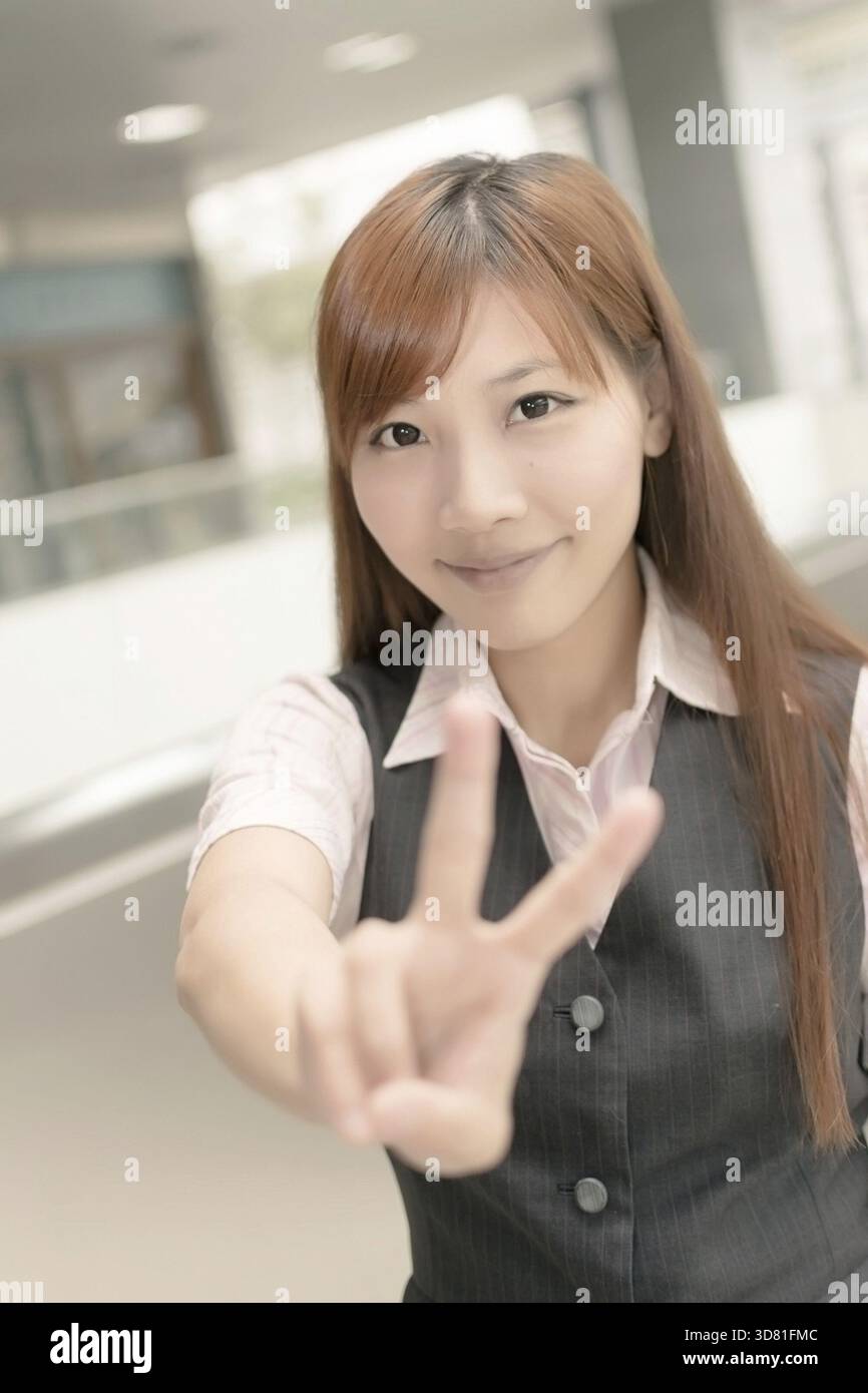 Femme d'affaires asiatique vous donner un geste de paix, gros plan portrait en dehors de Taipei, Taiwan, Asie Banque D'Images