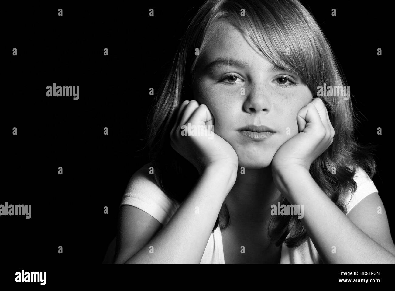 Fille qui est couchée onn het estomac semble s'ennuyer. Studioshot of Belgium Girl réalisé avec un Canon 5D sur fond noir, pays-Bas Banque D'Images