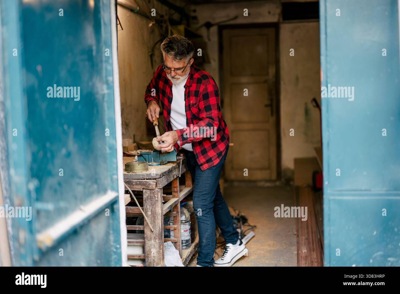 Artisan travaillant sur un projet en bois dans un atelier Banque D'Images