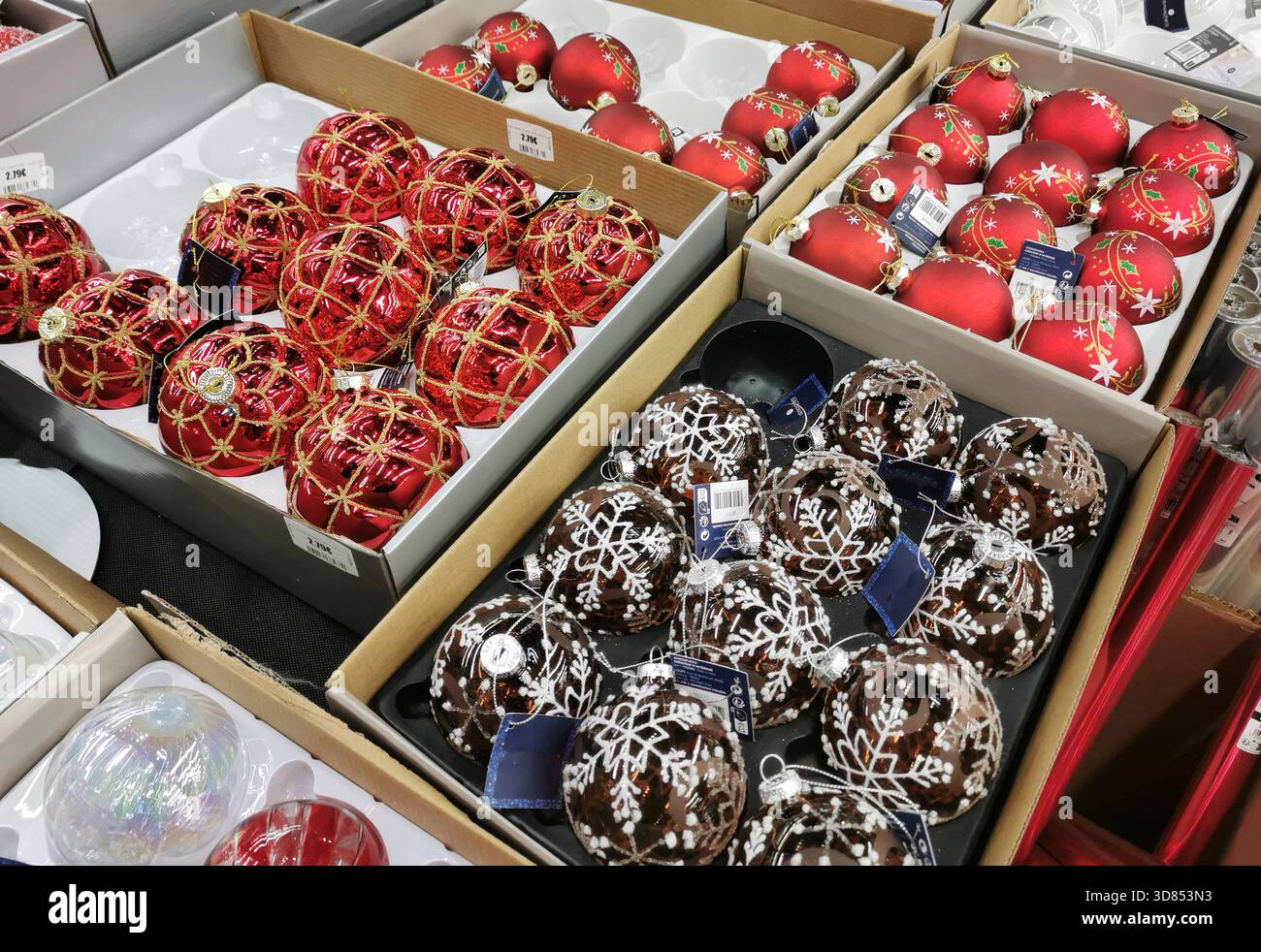 Plusieurs boîtes contiennent des ornements de Noël dans un magasin. Les ornements sont dans divers styles et couleurs. France - Image de stock capturée avec un smartphone