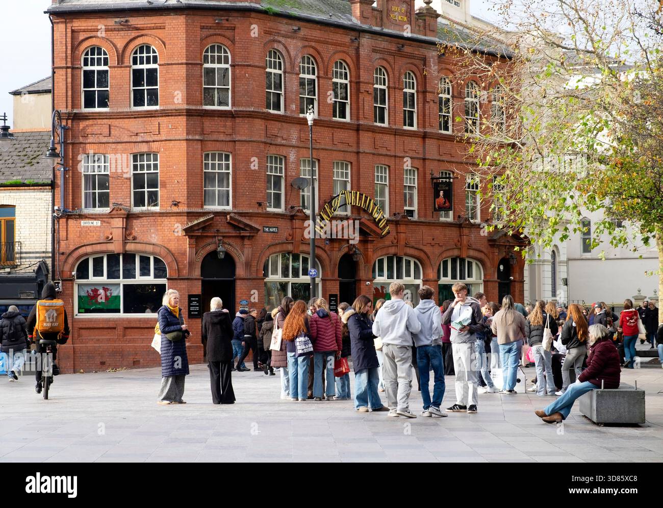 Les gens dans la rue debout devant le pub Duke of Wellington à Hayes place Cardiff City Centre Wales UK KATHY DEWITT Banque D'Images