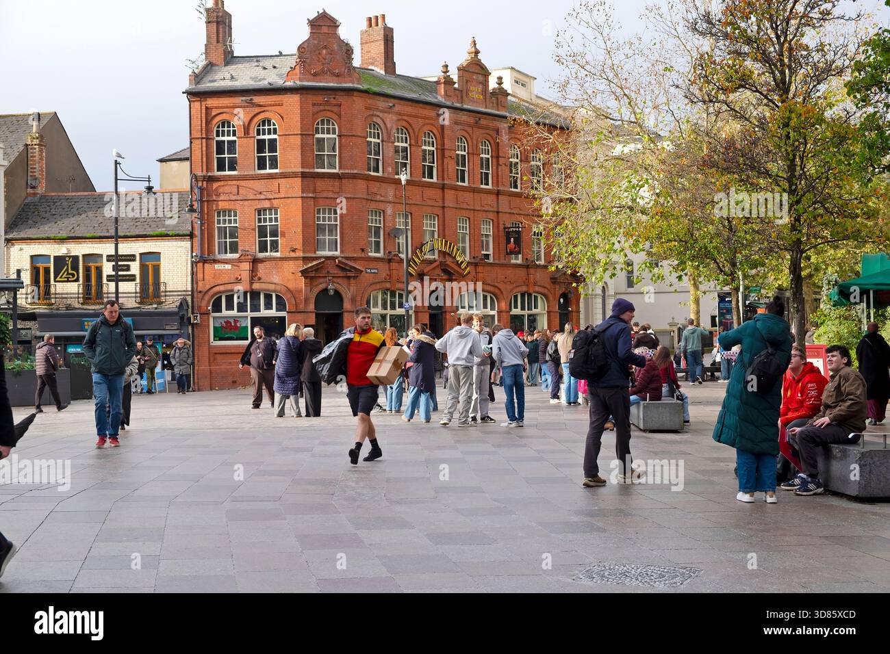 Les gens dans la rue debout devant le pub Duke of Wellington à Hayes place Cardiff City Centre Wales UK KATHY DEWITT Banque D'Images