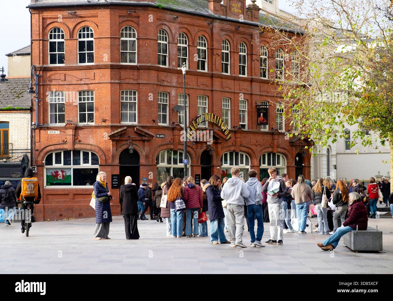 Personnes étudiants visitant le centre-ville de Cardiff debout dans la rue devant le pub Duke of Wellington à Hayes place Wales Royaume-Uni KATHY DEWITT Banque D'Images